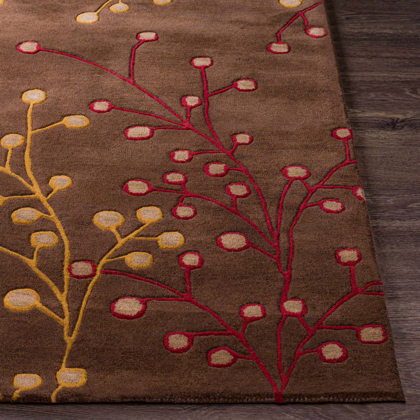 Close-up of the Brown Elsu Area Rug, a wool rug with a floral pattern in brown, burgundy, and gold on a dark wood floor. Front