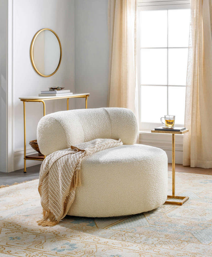 Living room scene with a Villareal Area Rug in cream, dusty pink, and ice blue under a white chair and gold accents. Styleshot