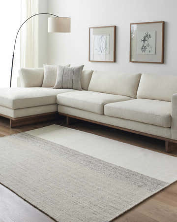 Living room scene with a Lieve Area Rug in ash, light silver, and silver gray under a modern sectional sofa. Roomscene-Rectangle