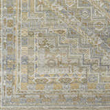 Close-up of the hand-knotted Ligao Area Rug. Features a traditional geometric pattern in charcoal, light gray, tan, and wheat. Swatch