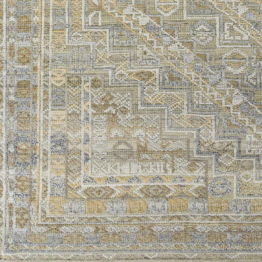 Close-up of the hand-knotted Ligao Area Rug. Features a traditional geometric pattern in charcoal, light gray, tan, and wheat. Swatch