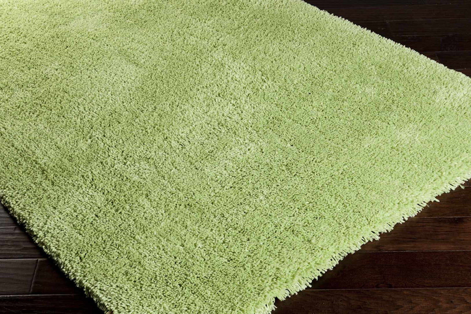 Close-up of a wheat-colored Lincolnton shag rug. The hand-woven rug has a soft, textured pile. Corner