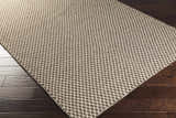 Close up of Lingo Brown Trellis Flatweave Rug showing dark brown and oatmeal diamond pattern on dark wood floor. Corner