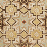 Close up of the hand woven Liscomb Area Rug, featuring a geometric pattern in brown, ivory, and pale blue. Swatch