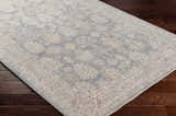 Close-up of Coby Brown Avant Garde rug showing traditional pattern in gray, beige, and gold on dark wood floors. Corner