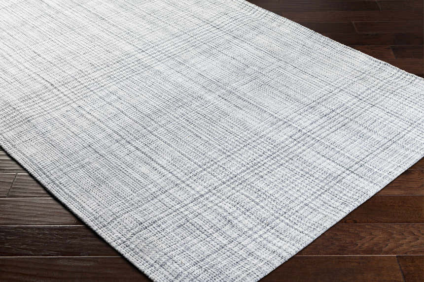 Close up of the Lubna Light Slate Area Rug showing the woven texture and slate, black, and charcoal colors. Corner