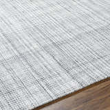 Close-up of the hand woven Lubna Light Slate Area Rug. Black, charcoal, and light slate hues create a subtle plaid pattern. Texture