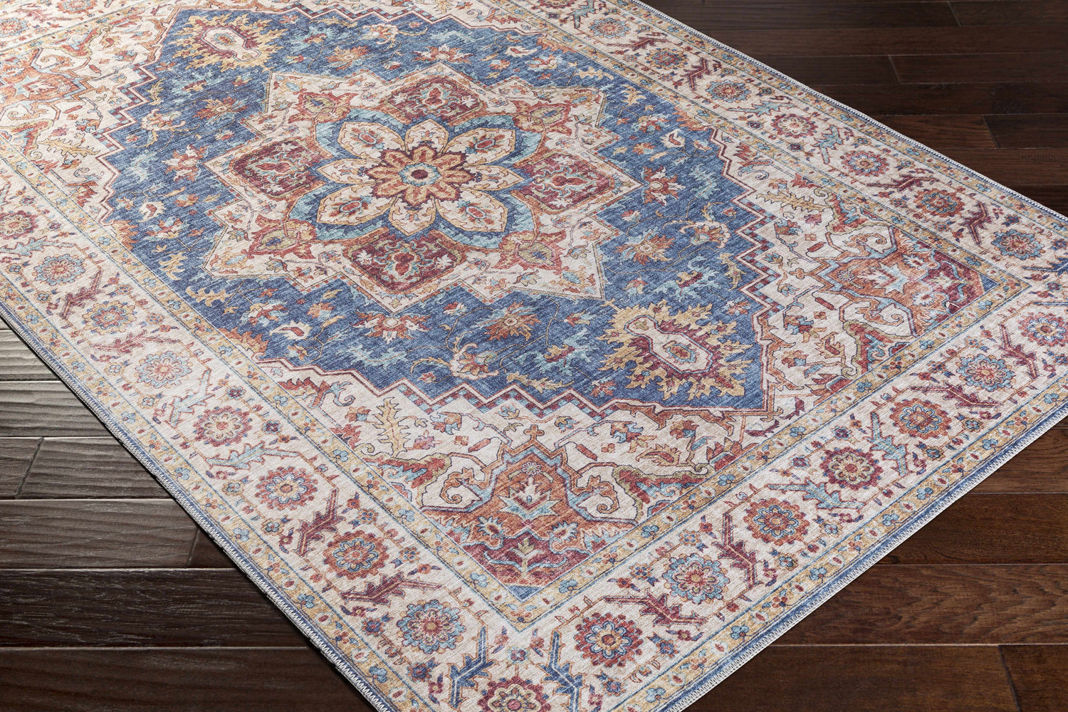 Close-up of the Kapaa Blue Medallion Rug, showcasing its traditional floral pattern in beige, blue, and burnt orange tones. Corner