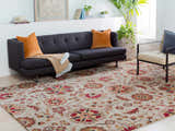 Living room scene with a Longford Beige Floral rug, gray sofa with orange pillows, and a modern chair. Roomscene-Rectangle