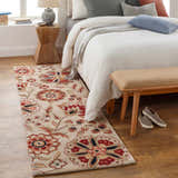 Bedroom scene with Longford Beige Floral rug, wood floors, white bedding, and neutral accents. Roomscene-Runner