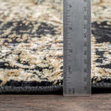 Close up of Lostwithiel Black Medallion Rug showing pile height with a ruler. Colors include black, beige, and tan. Pile