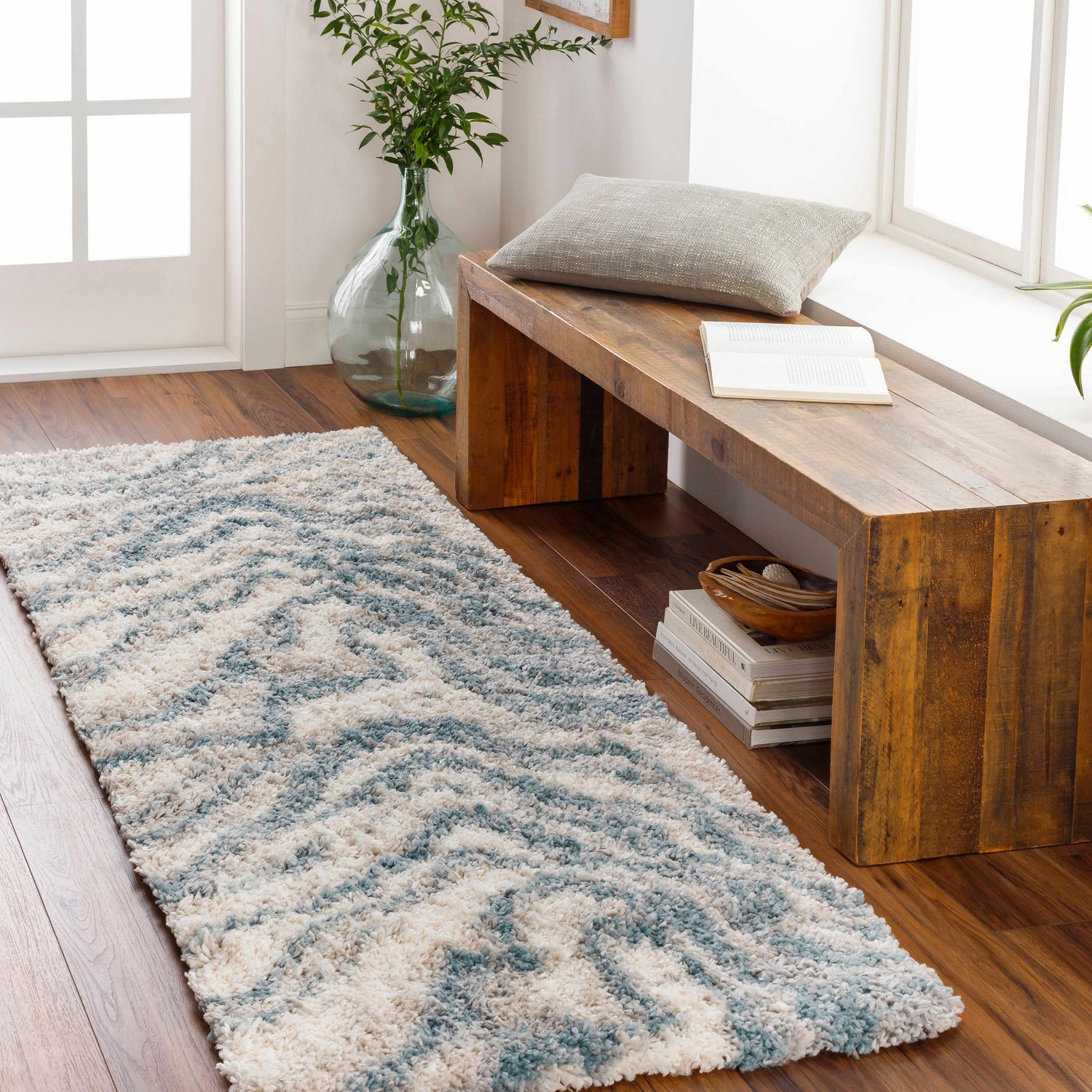Hallway scene with a blue and cream Lottery Area Rug, wood bench, and bright natural light. Roomscene-Runner