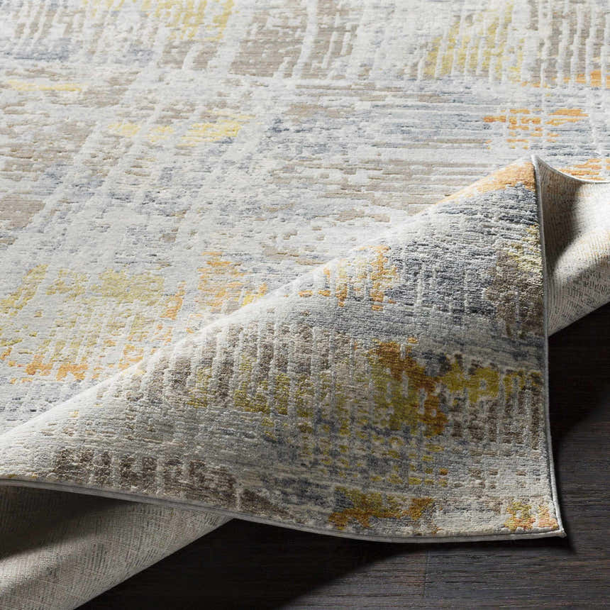 Close-up of the Ludington Area Rug showing its textured, distressed design in ivory, gray, yellow, and brown tones. Fold