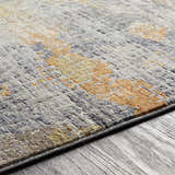 Close-up of the Ludington Area Rug showing its gray, ivory, and orange vintage-style pattern and textured machine-woven construction. Texture