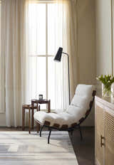Living room scene with a Fadri Area Rug, beige chair, side tables, and sheer curtains. Neutral tones. Styleshot