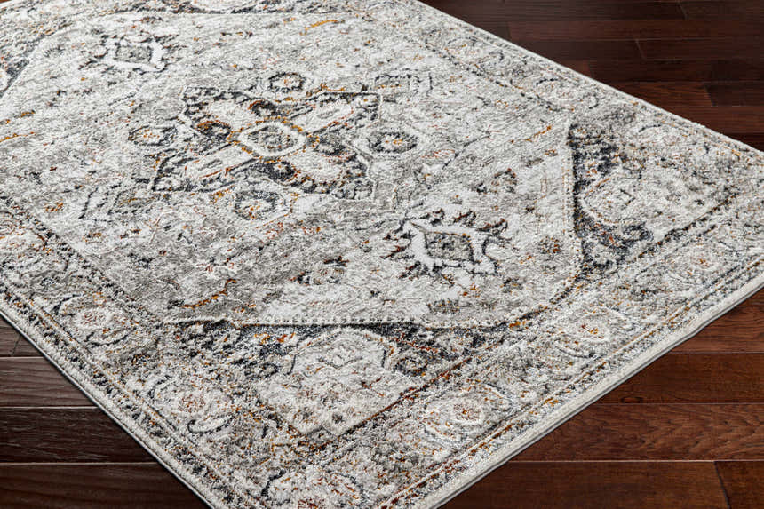 Close-up of the Liverpool Dark Gray Area Rug showing its traditional charcoal, gray, rust, and off-white pattern. Corner