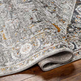 Close-up of the Liverpool Dark Gray Area Rug showing charcoal, gray, rust, and mustard tones and machine-woven texture. Fold