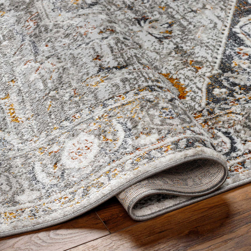 Close-up of the Liverpool Dark Gray Area Rug showing charcoal, gray, rust, and mustard tones and machine-woven texture. Fold