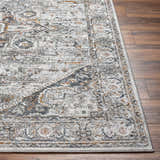 Close-up of the Liverpool Dark Gray Area Rug showing its traditional charcoal, gray, and rust colored pattern. Front