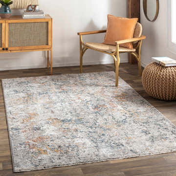 Living room scene with a Lydney Luxe Rug, wood cabinet, woven chair with orange pillow, and woven ottoman. Roomscene-Rectangle