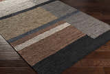 Close-up of the Lyndoch Leather Patchwork Rug. Features black, brown, and gray leather patches on a dark wood floor. Corner