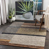 Living room scene with a Lyndoch Leather Patchwork Rug in black, brown, and beige tones under a mid-century modern chair. Roomscene-Rectangle