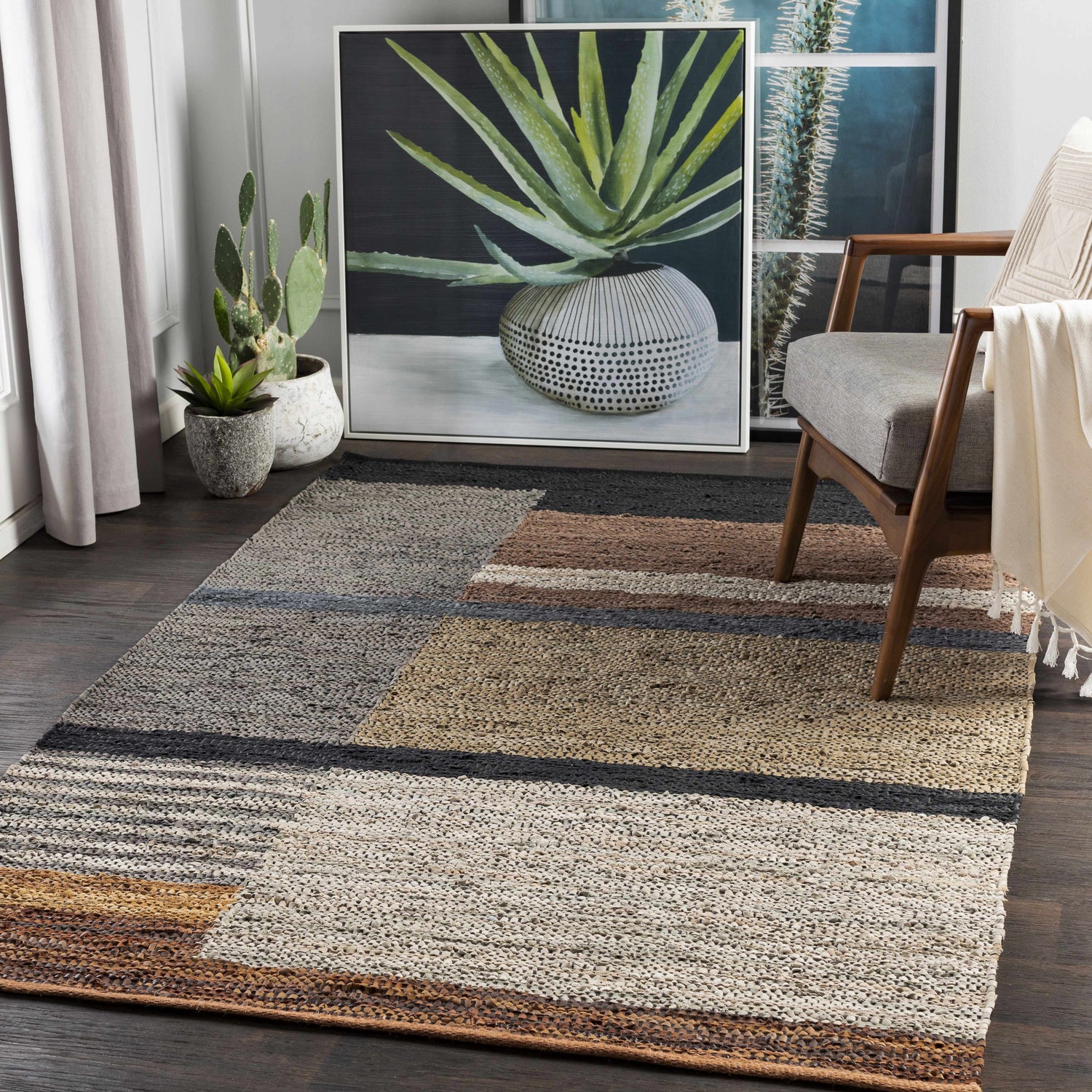 Living room scene with a Lyndoch Leather Patchwork Rug in black, brown, and beige tones under a mid-century modern chair. Roomscene-Rectangle