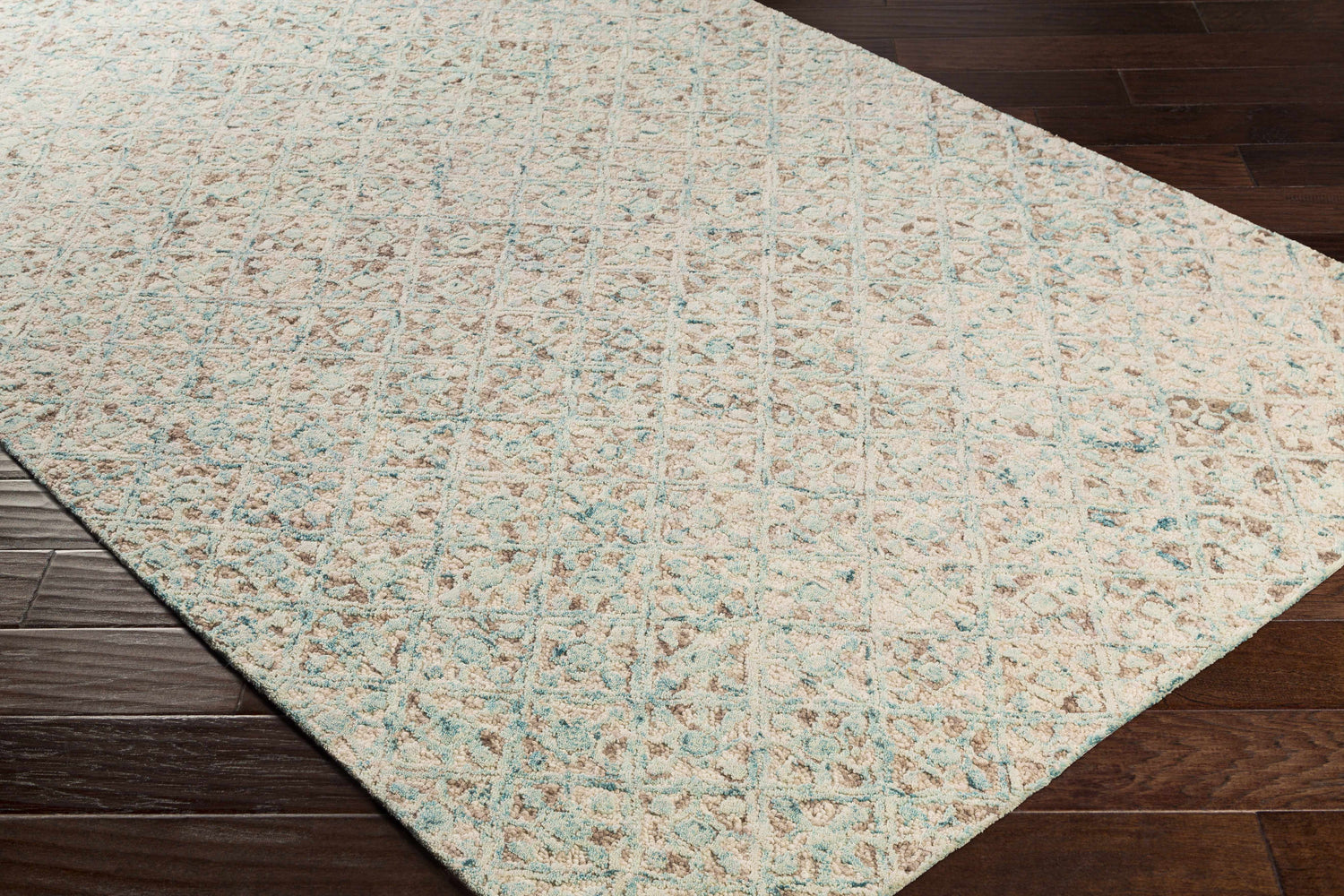 Close-up of the hand-tufted Lysander Area Rug. Wool rug in light beige, blue, and brown with a contemporary pattern. Corner