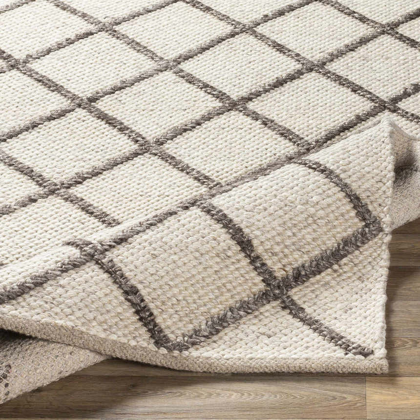 Close-up of the Syosset Cream/Brown Trellis Rug showing its wool texture and geometric trellis pattern. Fold