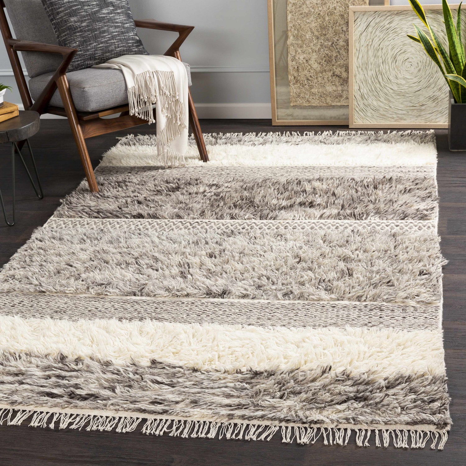 Living room scene with a gray chair and the Elizabeth Area Rug, a shaggy beige and gray rug with stripes. Roomscene-Rectangle
