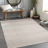 Entryway with gray Maanas Washable Area Rug, wood bench, round mirror, plants, and books for a cozy, transitional style. Roomscene-Rectangle