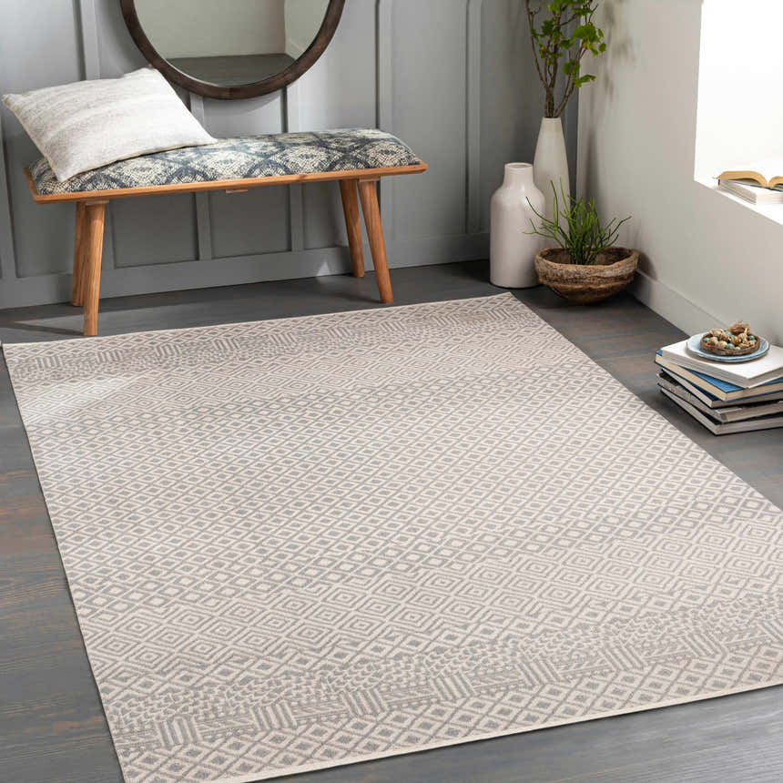 Entryway with gray Maanas Washable Area Rug, wood bench, round mirror, plants, and books for a cozy, transitional style. Roomscene-Rectangle