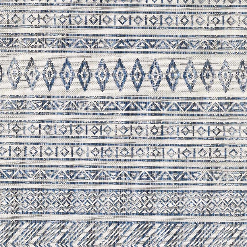 Close-up of Madras Light Blue Green All Over Performance Area Rug with blue geometric patterns on a light background. Swatch