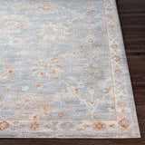 Close-up of the Mangham Thick Luxe Area Rug featuring a blue, brick red, and light beige oriental pattern. Front