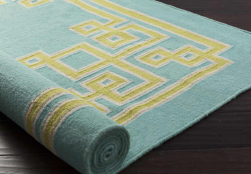 Close-up of a rolled Manitou Area Rug. Aqua wool rug with a geometric light olive and gray pattern. Hand woven texture. Styleshot