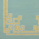 Close-up of the Manitou Area Rug showing its aqua wool texture and light olive geometric border pattern. Swatch