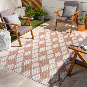 Outdoor patio scene with Mansilingan 3D Area Rug in bone and dark beige. Geometric rug under wood chairs, plants, and stone table. Roomscene-Rectangle