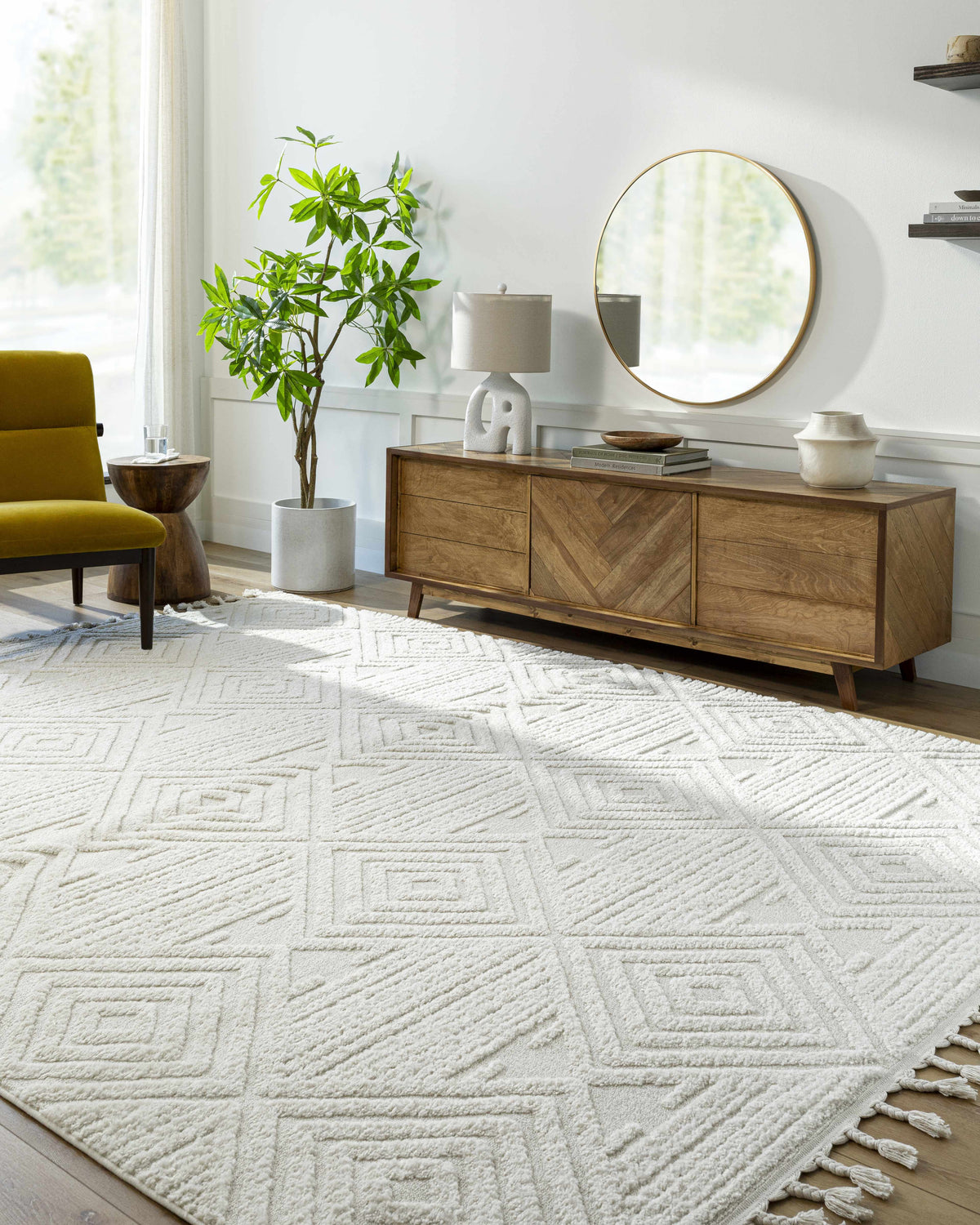 Living room with a Bone Manyas 3D Area Rug, wood console table, round mirror, and olive green chair. Roomscene-Rectangle