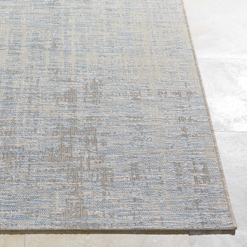 Close-up of the Manzanita Area Rug. Blue, cream, and taupe hues create a contemporary pattern. Machine woven texture. Front