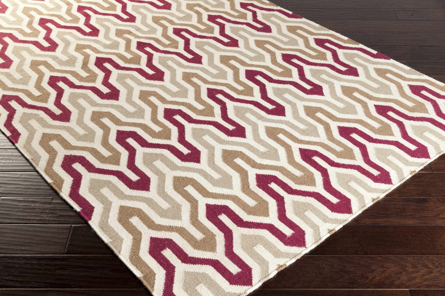 Close-up of Markesan Wool Area Rug. Dark red, ivory, and brown geometric pattern. Hand woven texture. Corner