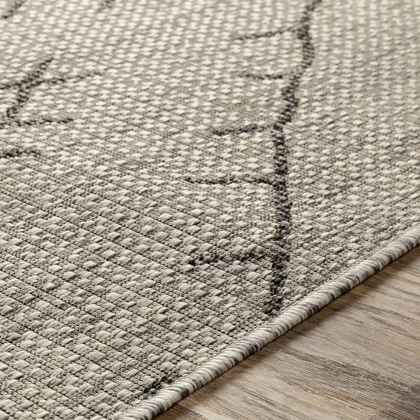Close-up of the Marwood Nordic Performance Rug showing its charcoal and white geometric pattern and textured weave. Texture