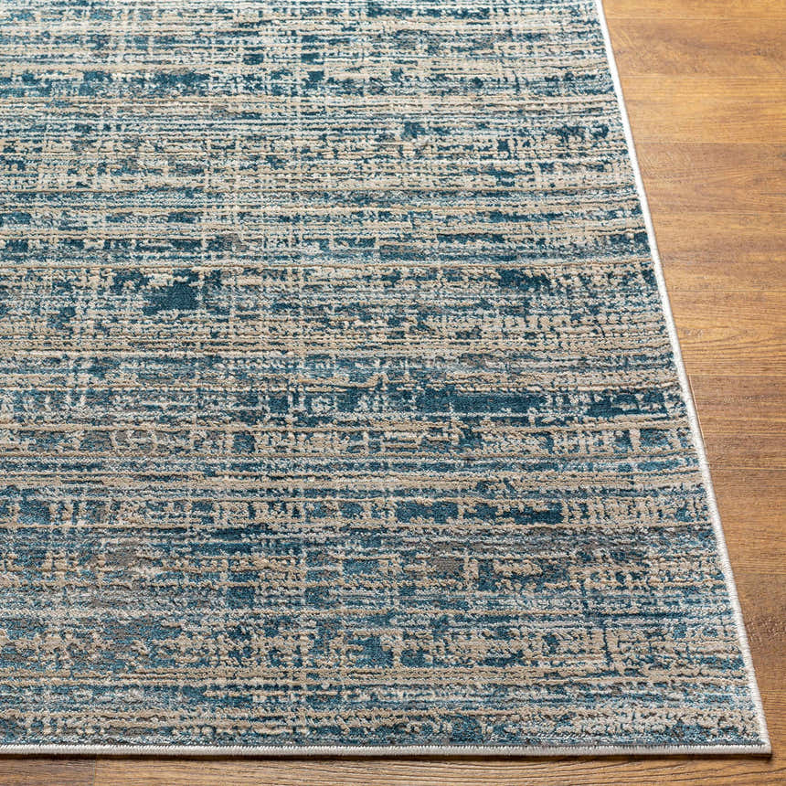 Close-up of the Maungatapere Area Rug, a contemporary rug in cream, gray, and teal on a wood floor. Front