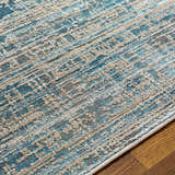 Close-up of the Maungatapere Area Rug, showcasing its contemporary teal, beige, and gray pattern and machine-woven texture. Texture