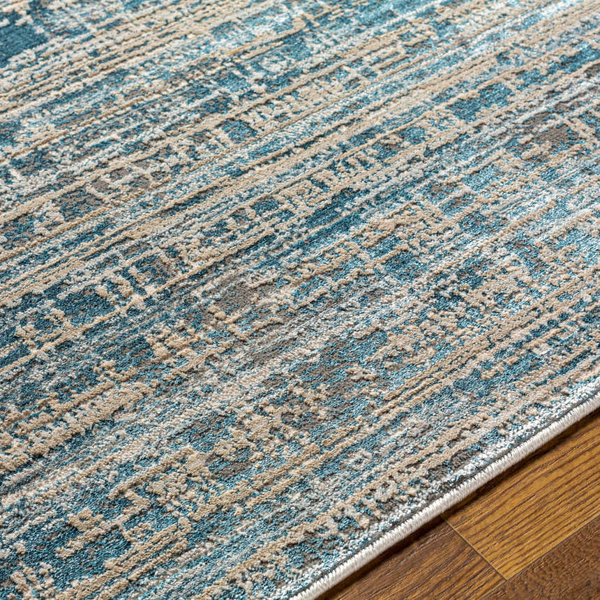 Close-up of the Maungatapere Area Rug, showcasing its contemporary teal, beige, and gray pattern and machine-woven texture. Texture