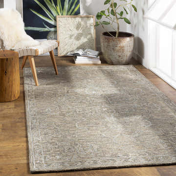 Bright room scene with a light sage Maysville Wool & Faux Silk Rug, wood floors, chair, and potted plant. Roomscene-Rectangle