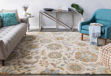 Living room scene with a Mack Floral Wool Area Carpet in brown, denim, and sage. Sofa, blue chair, and modern table. Roomscene-Rectangle