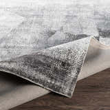 Close-up of McDowall Viscose Area Rug showing its gray, charcoal, and cream contemporary pattern and hand-loomed construction. Fold