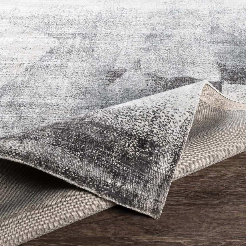 Close-up of McDowall Viscose Area Rug showing its gray, charcoal, and cream contemporary pattern and hand-loomed construction. Fold