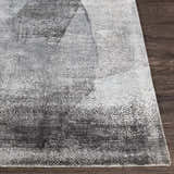 Close-up of the McDowall Viscose Area Rug showing its abstract pattern in black, charcoal, cream, and gray tones. Front