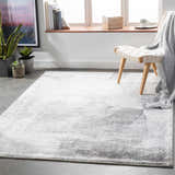 Minimalist living room scene with gray McDowall Viscose Area Rug, woven chair, plants, and natural light. Roomscene-Rectangle